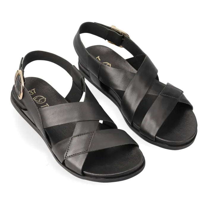 A pair of black leather flat sandals with crisscross straps and adjustable ankle straps, shown on a white background.