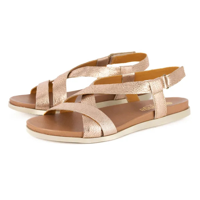 Pair of rose gold sandals on a white background