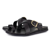 Black criss cross sandals with a gold buckle on a white background
