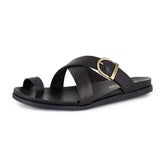 Black criss cross sandal with a gold buckle on a white background