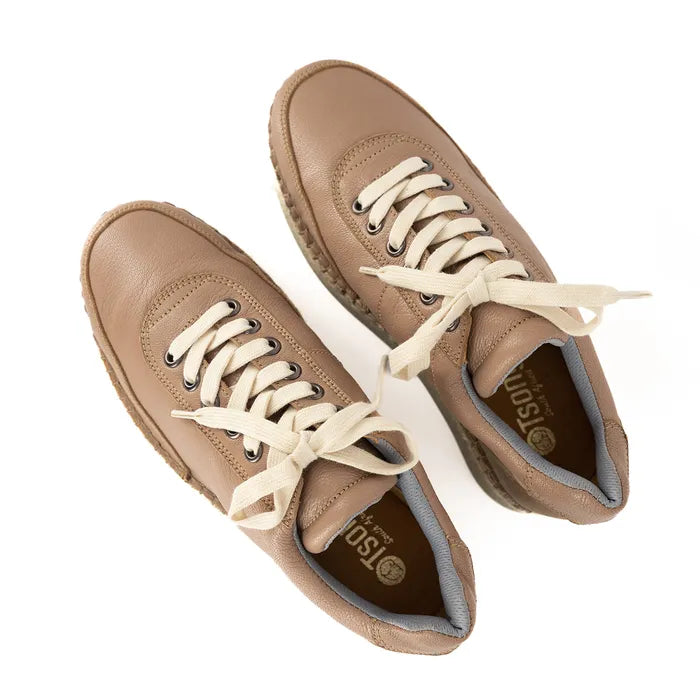 Pair of tan sneakers with white laces on a white background