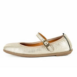 Gold metallic flat pump with a strap on a white background