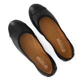 Pair of black flat shoes with brown soles on a white background