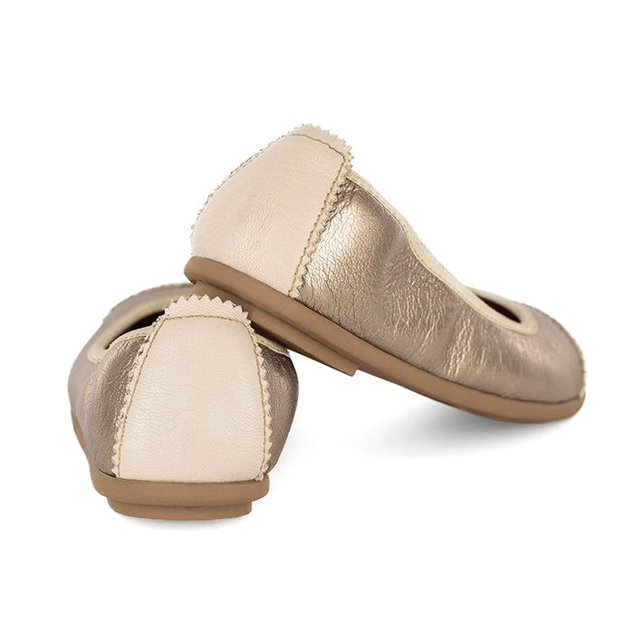 Pair of gold and beige flat shoes on a white background