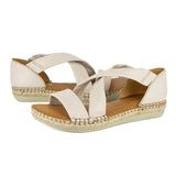 Pair of cream-colored sandals with espadrille sole on a white background