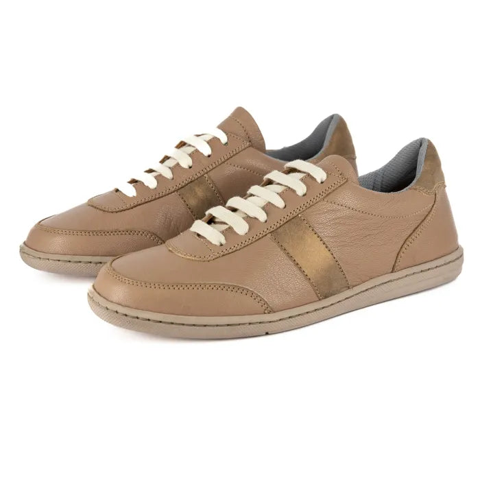 Pair of tan sneakers with white laces on a white background