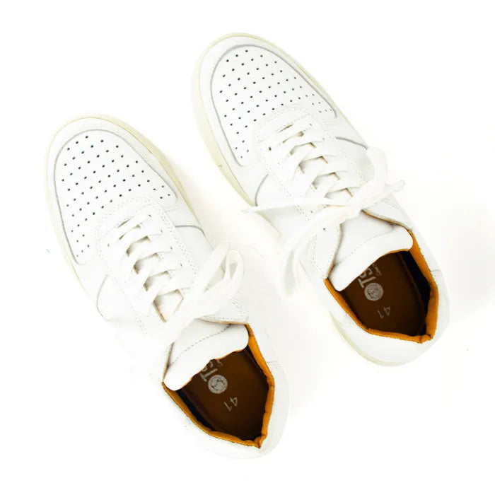 White sneakers with off-white soles on a white background