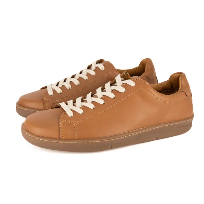 Pair of tan leather sneakers with white laces on a white background