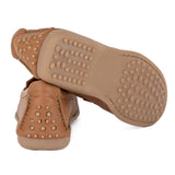 Tan shoe with a textured sole on a white background
