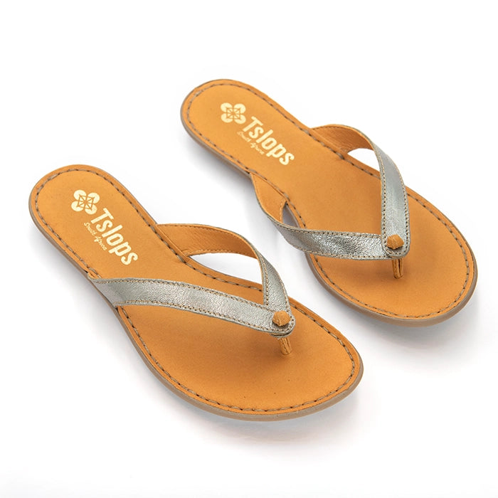 A pair of women's thong sandal from Tsonga, featuring a metallic silver strap and a tan footbed, shown on a clean white background.