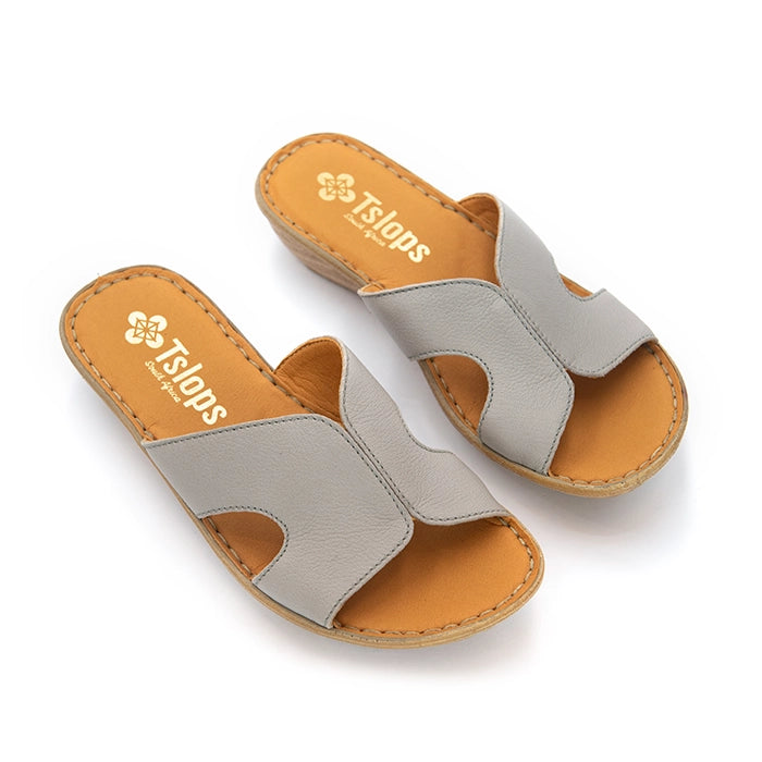 A pair of Tslops slide sandals in light gray leather with tan insoles and low stacked heels, shown on a white background.