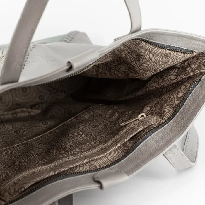 Grey handbag with a patterned interior on a white background