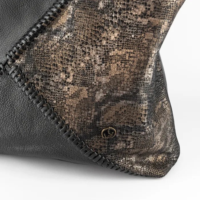 Close-up of a textured clutch bag with a gold clasp on a white background