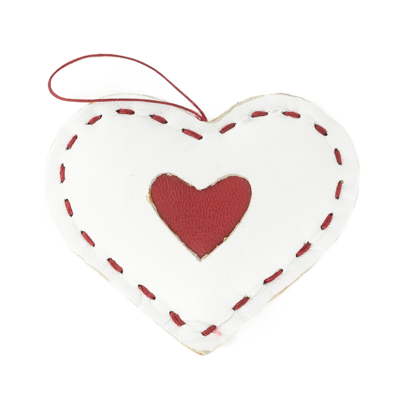 A small, white, heart-shaped Christmas decor accessory with red stitching and a red hanging ribbon.