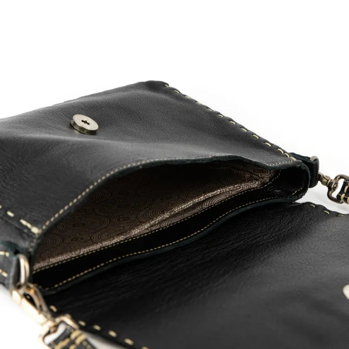 Close-up of a black leather handbag with gold accents on a white background