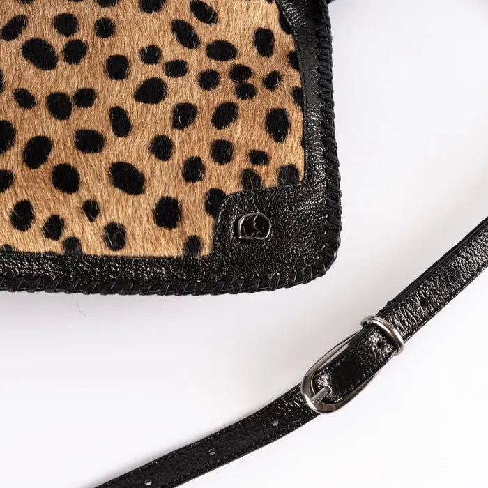 Spotted print clutch bag with black strap on a white background