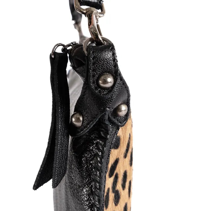 Close-up of a black leather pouch with spotted print accents on a white background