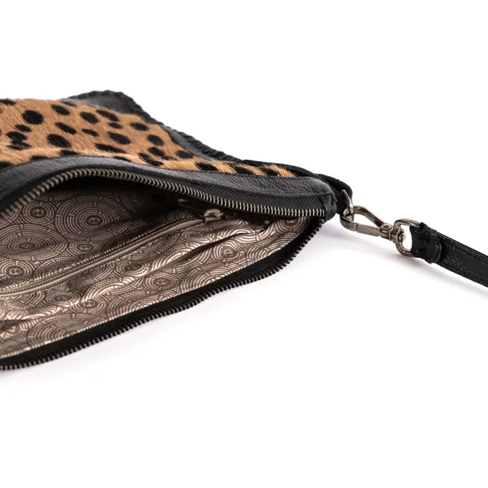 Spotted print clutch bag with patterned interior on a white background