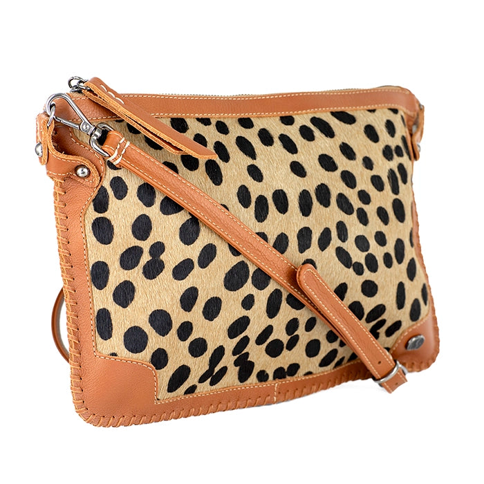 Cheetah print handbag with tan leather strap on a white background