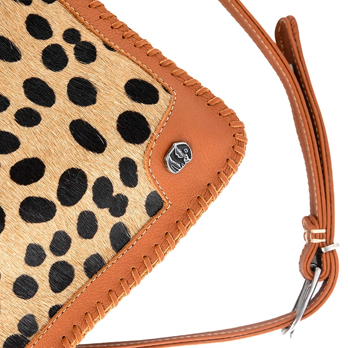 Close-up of a handbag with lcheetah print and tan leather accents, featuring a brand logo.