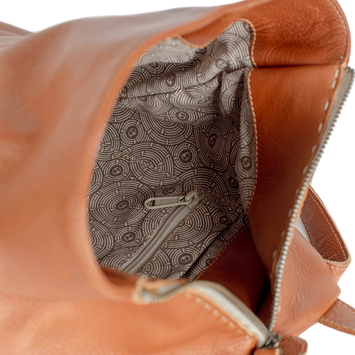 Close-up of a tan leather bag with a patterned interior pocket.