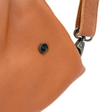 Close-up of a tan leather handbag with a visible brand logo on a white background