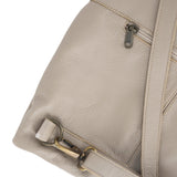 Close-up of a beige leather bag with a strap and zipper detail on a white background