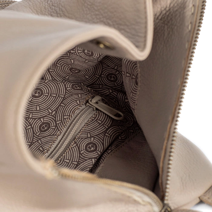 Close-up of a beige leather bag with a patterned interior pocket.
