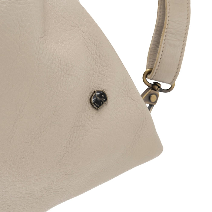 Close-up of a beige handbag with a visible brand logo on a white background