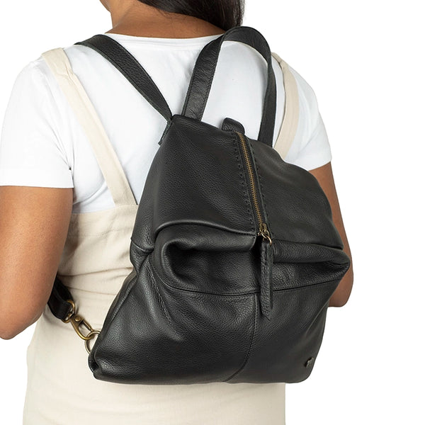 Person wearing a black leather backpack on a white background