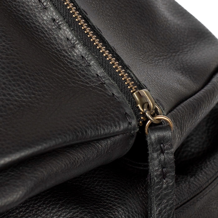 Close-up of a black leather bag with a gold zipper.