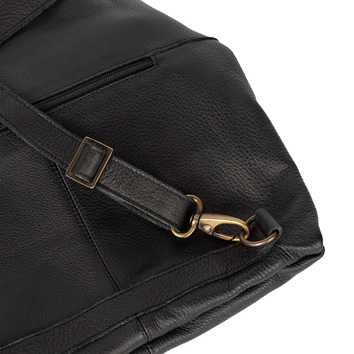 Close-up of a black leather bag with a gold buckle on a white background