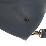 Close-up of a denim eather bag with a gold clasp on a white background