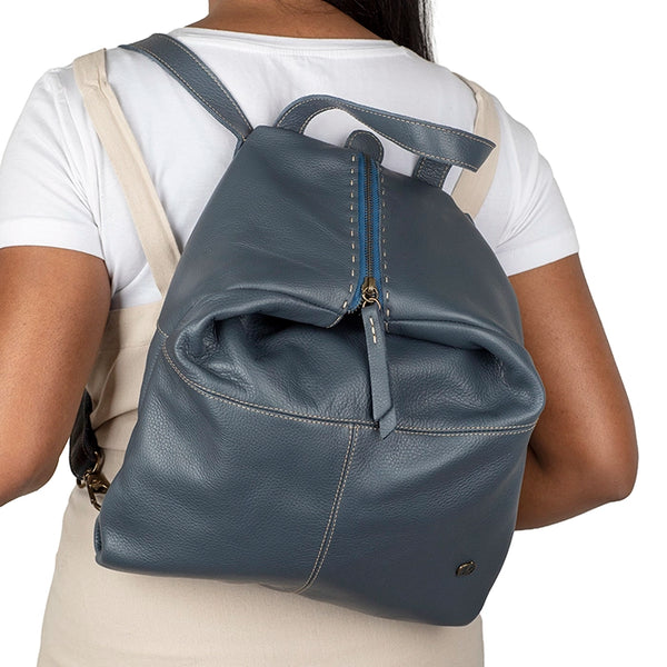 Person wearing a denim backpack on a white background