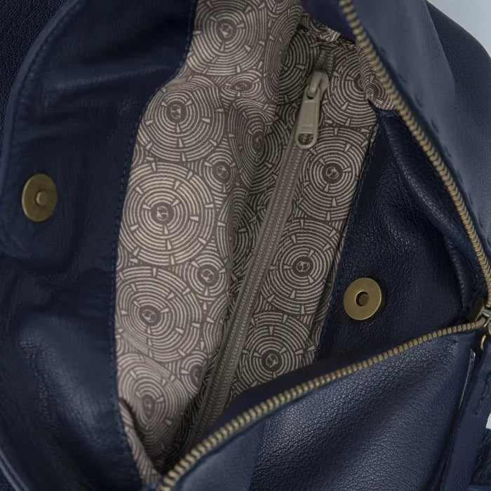 Close-up of a blue leather jacket with a patterned lining and gold buttons.