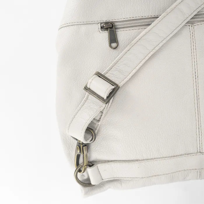 Close-up of a cream leather bag with silver hardware on a white background