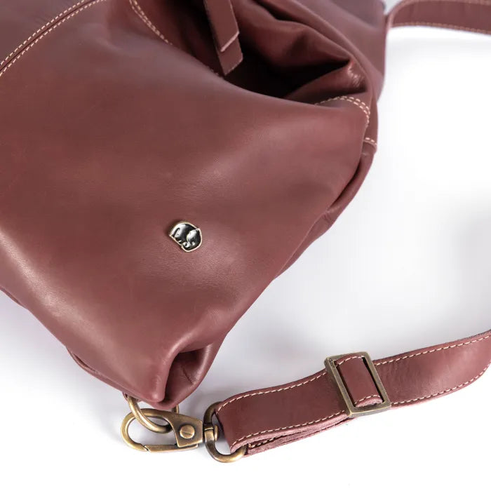 Maroon leather handbag with gold hardware on a white background