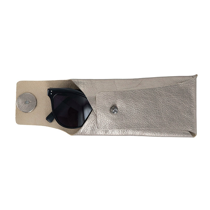 Metallic sunglasses case with a pair of black sunglasses inside on a white background