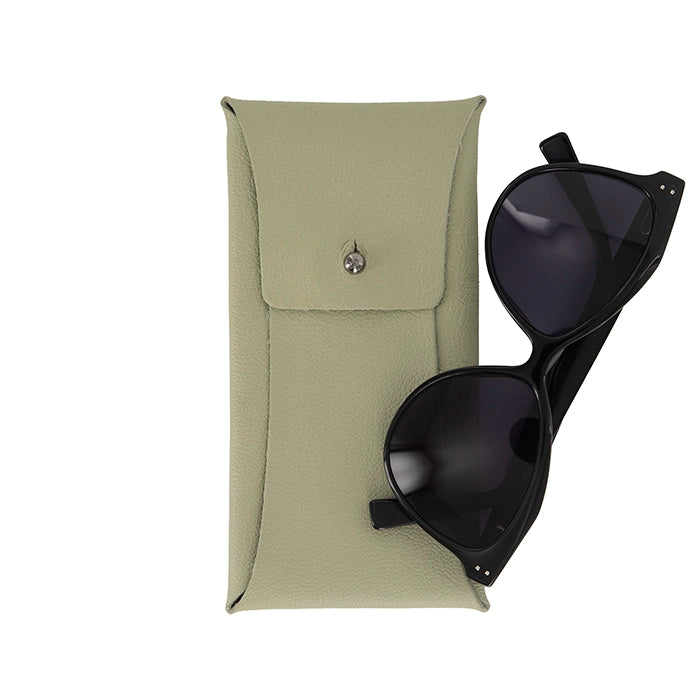 Black sunglasses placed next to a light sage green textured leather case featuring a button closure.