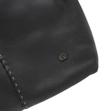 Close-up of a black leather bag with a brand logo on a white background