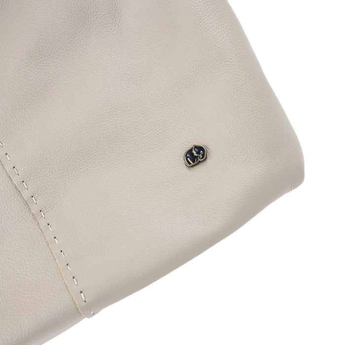 Close-up of a beige leather product with a brand logo on a white background