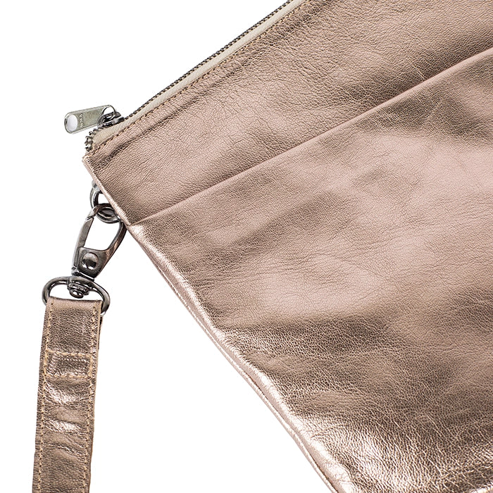 Close-up of a metallic gold cross body bag with a strap on a white background