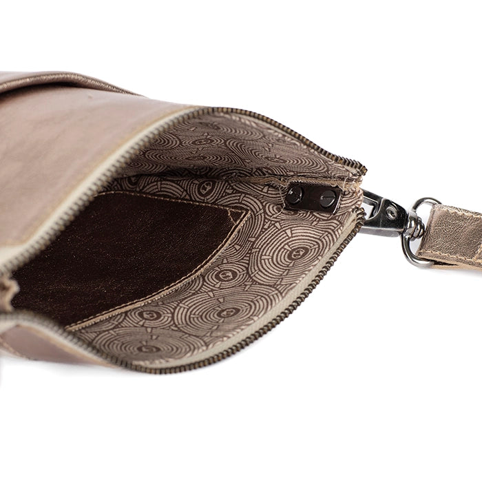 Close-up of a gold leather handbag with intricate interior pattern on a white background