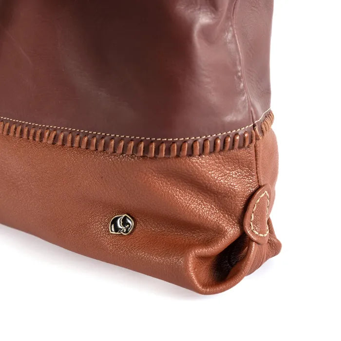 Close-up of a maroon and brown leather bag with a brand logo on a white background