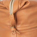Close-up of a tan leather bag with a zipper