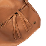 Tan leather handbag with decorative straps on a white background