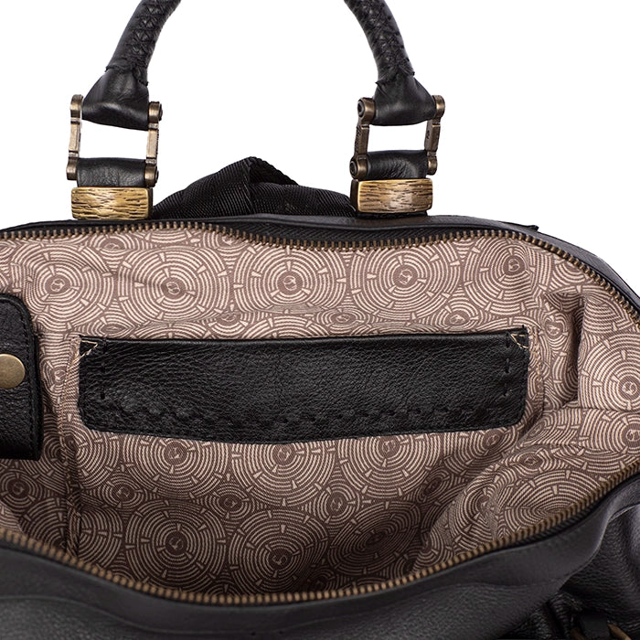 Close-up of a patterned handbag with a gold buckle on a white background