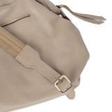 Beige handbag with a strap and buckle on a white background