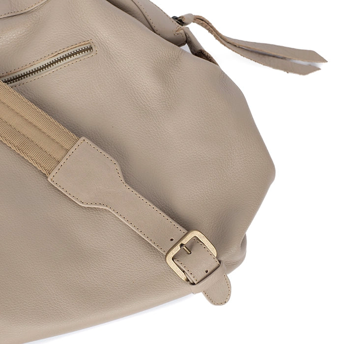 Beige handbag with a strap and buckle on a white background
