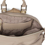 Close-up of a beige handbag with intricate patterned interior.